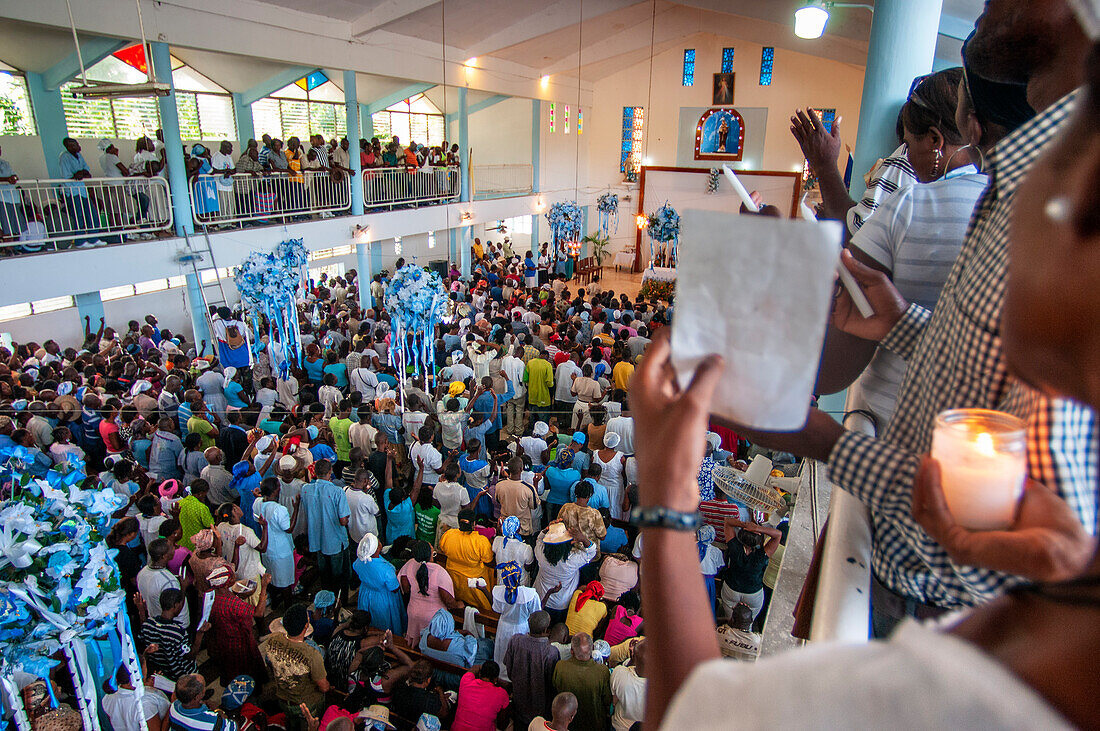 Im Inneren der Kirche Unserer Lieben Frau vom Berge Karmel. Haiti Voodoo-Festival in Saut d'Eau, in Saut d'Eau, Ville Bonheur, Haiti. Tausende von Vodou- und katholischen Anhängern versammelten sich unter dem Wasserfall von Saut d'Eau in Haiti. Die Wallfahrt, die sowohl von Voodou-Anhängern als auch von Katholiken unternommen wird, hat ihren Ursprung in der Sichtung des Bildes der Jungfrau Maria auf einem Palmblatt in der Nähe des Wasserfalls vor einem halben Jahrhundert. Der Katholizismus und die Voodou-Praktiken sind in ihrer haitianischen Form für immer miteinander verwoben. Das Erscheinen 