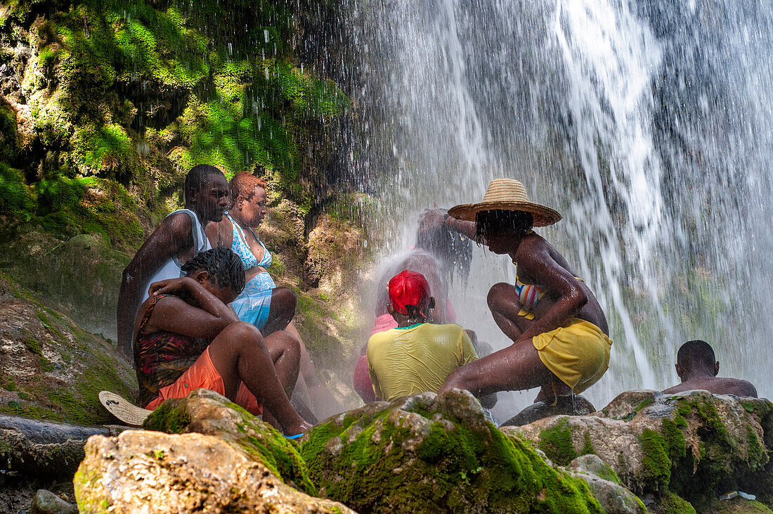 Haiti Voodoo Festival in Saut d'Eau, in Saut d'Eau, Ville Bonheur, Haiti. Tausende von Vodou- und katholischen Anhängern versammelten sich unter dem Wasserfall von Saut d'Eau in Haiti. Die Wallfahrt, die sowohl von Voodou-Anhängern als auch von Katholiken unternommen wird, hat ihren Ursprung in der Sichtung des Bildes der Jungfrau Maria auf einem Palmblatt in der Nähe des Wasserfalls vor einem halben Jahrhundert. Der Katholizismus und die Voodou-Praktiken sind in ihrer haitianischen Form für immer miteinander verwoben. Das Erscheinen eines Regenbogens unter den Wasserfällen soll bedeuten, dass