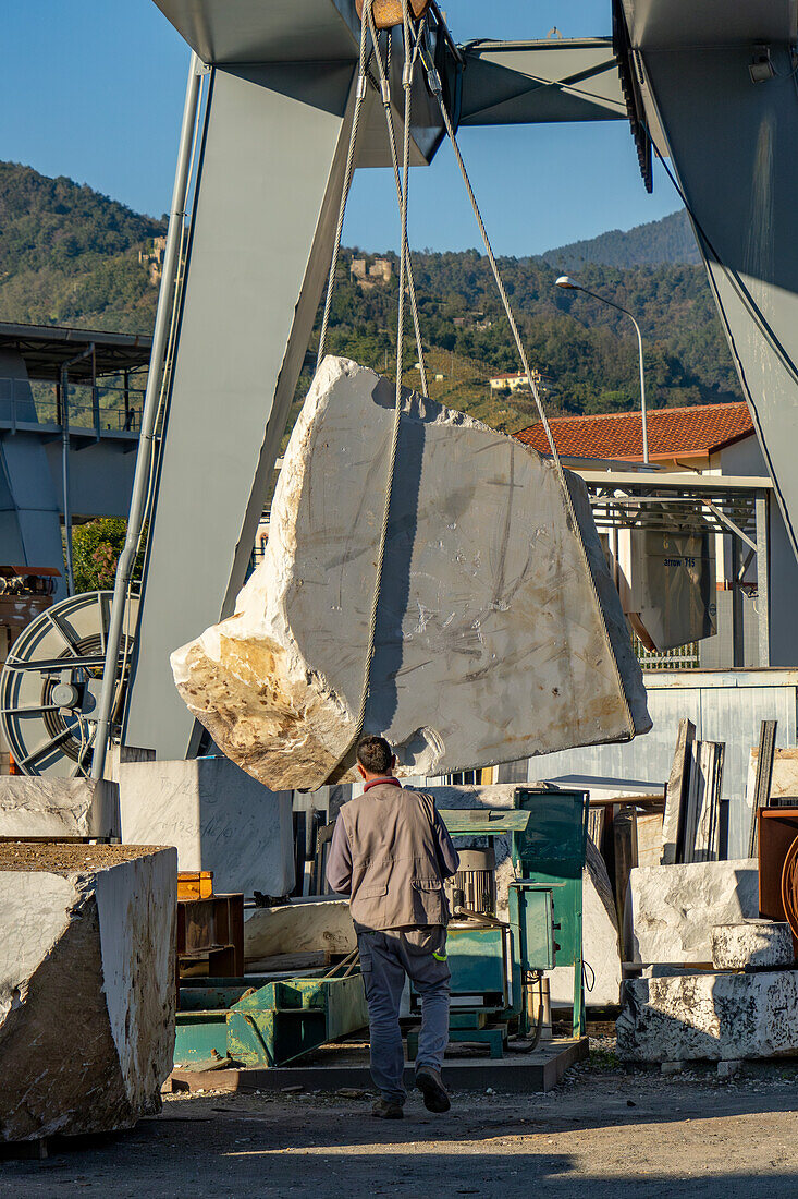 A gantry crane moves a large block of marble at a marble supply company in Carrara, Italy.