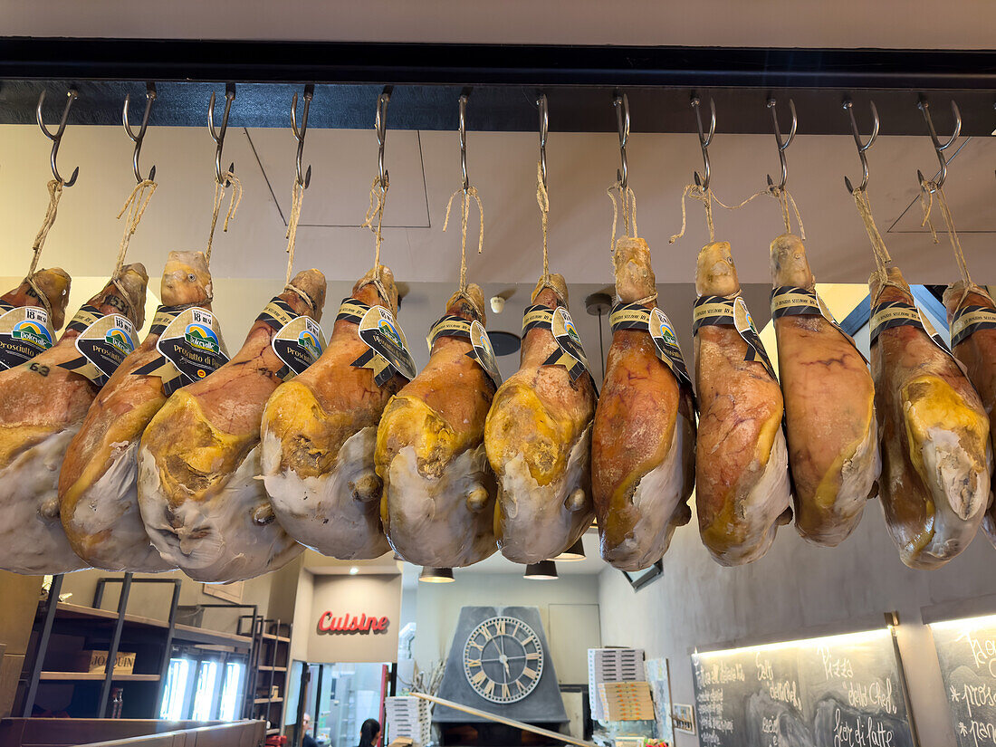 Prosciutto di Parma hams hanging in a pizzeria restaurant in Sorrento, Italy.