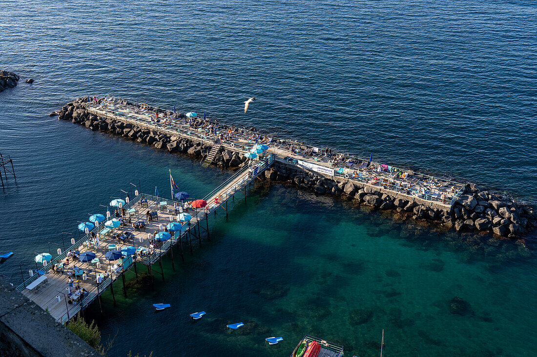 Ein Restaurant und eine Liegewiese auf einem Erholungspier in der Bucht von Neapel bei Sorrent, Italien.