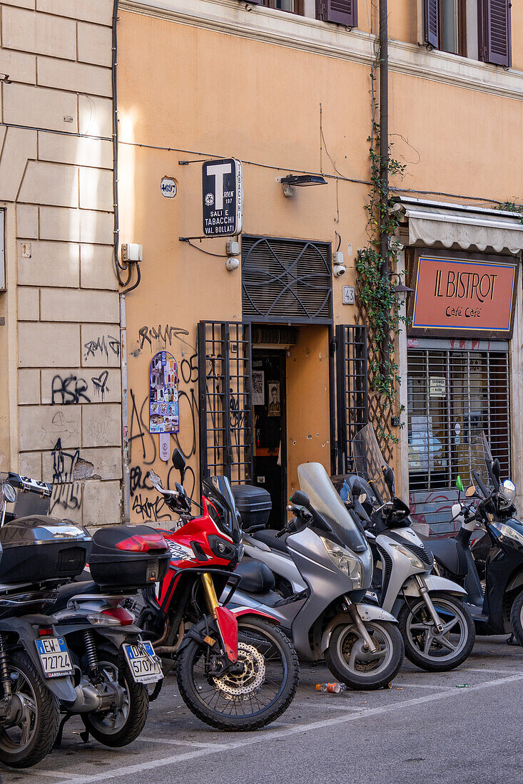 Motorcycles and motorscooters parked on a street in Rome, Italy.