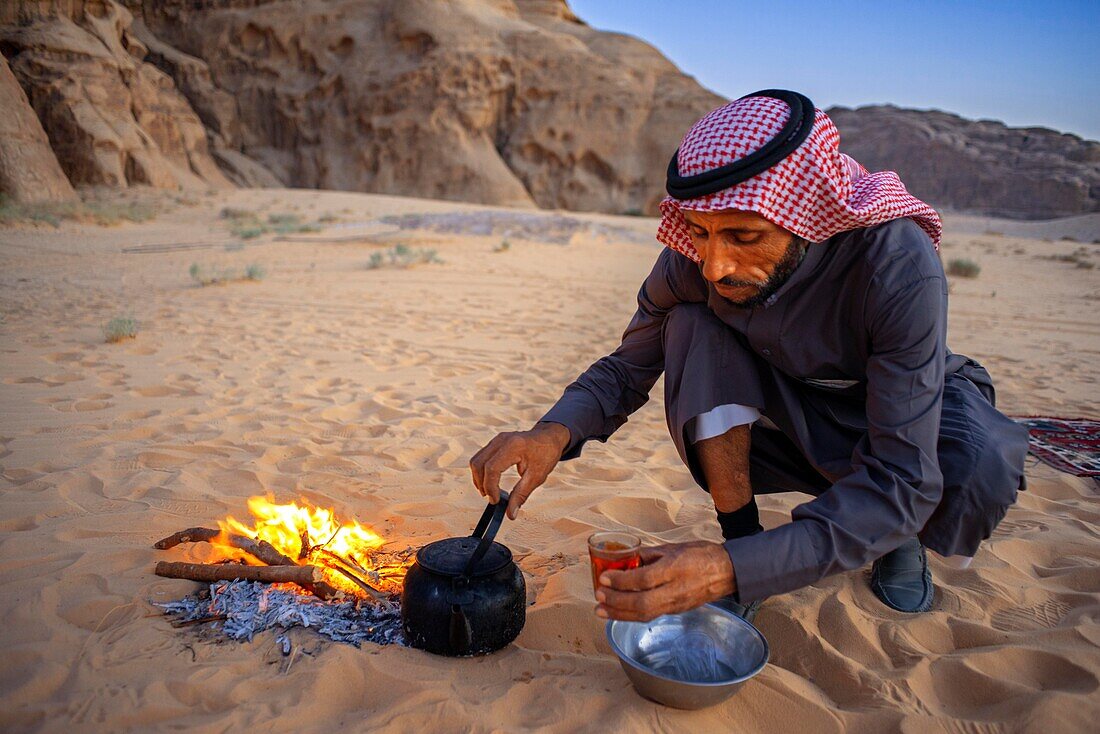 Bedouin making tea on open fire in the desert of Wadi Rum, Jordan