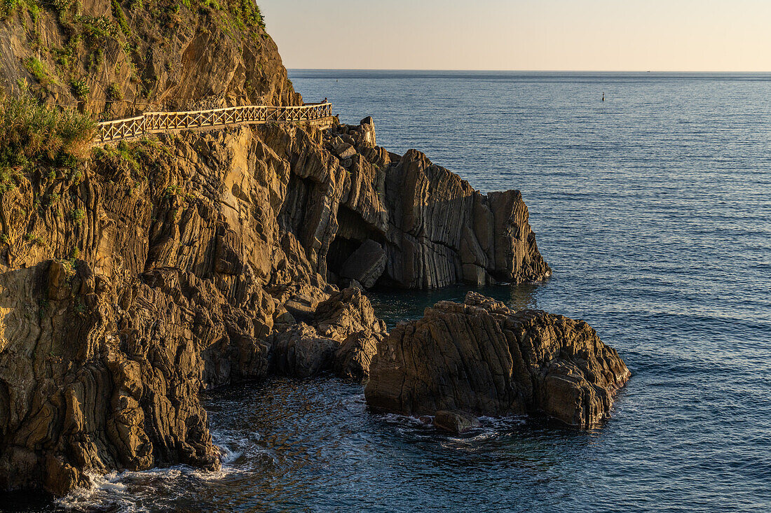 A walkway on the rocks along the water of the Lingurian Sea by Riomaggiore, Cinque Terre, Italy.