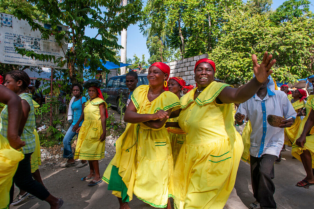 Haiti Voodoo Festival in Saut d'Eau, in Saut d'Eau, Ville Bonheur, Haiti. Tausende von Vodou- und katholischen Anhängern versammelten sich unter dem Wasserfall von Saut d'Eau in Haiti. Die Wallfahrt, die sowohl von Voodou-Anhängern als auch von Katholiken unternommen wird, hat ihren Ursprung in der Sichtung des Bildes der Jungfrau Maria auf einem Palmblatt in der Nähe des Wasserfalls vor einem halben Jahrhundert. Der Katholizismus und die Voodou-Praktiken sind in ihrer haitianischen Form für immer miteinander verwoben. Das Erscheinen eines Regenbogens unter den Wasserfällen soll bedeuten, dass