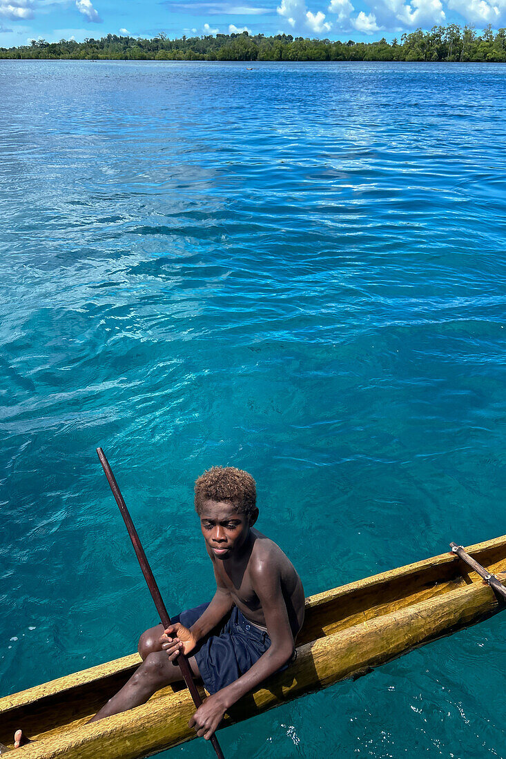 Residents of Tungelo Island in their traditional dugout canoes, New Ireland province, Papua New Guinea