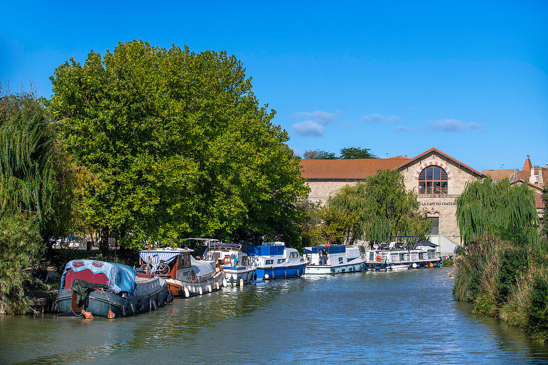 La Cave du château, Colombiers. Canal du Midi at Colombiers Aude South of France southern waterway waterways holidaymakers queue for a boat trip on the river, France, Europe