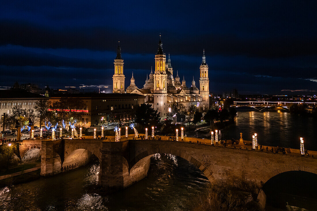 Luftaufnahme der Kathedrale Basilika Unserer Lieben Frau von der Säule und der in der Weihnachtszeit beleuchteten Steinernen Brücke, Zaragoza, Spanien