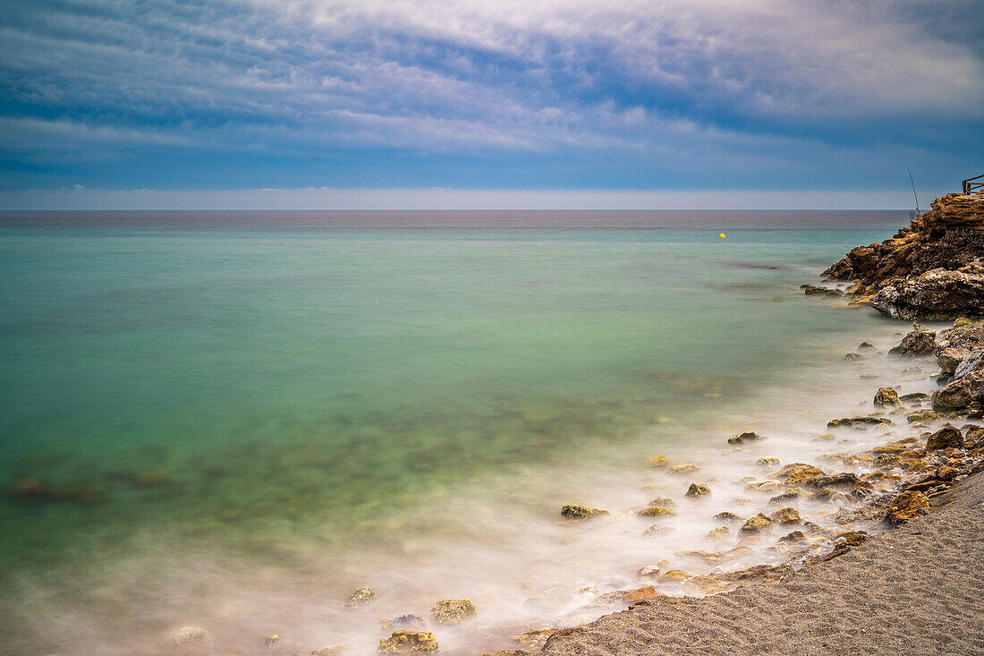 Langzeitbelichtung des Strandes Torrecilla in Nerja, Malaga, die seine Schönheit hervorhebt.