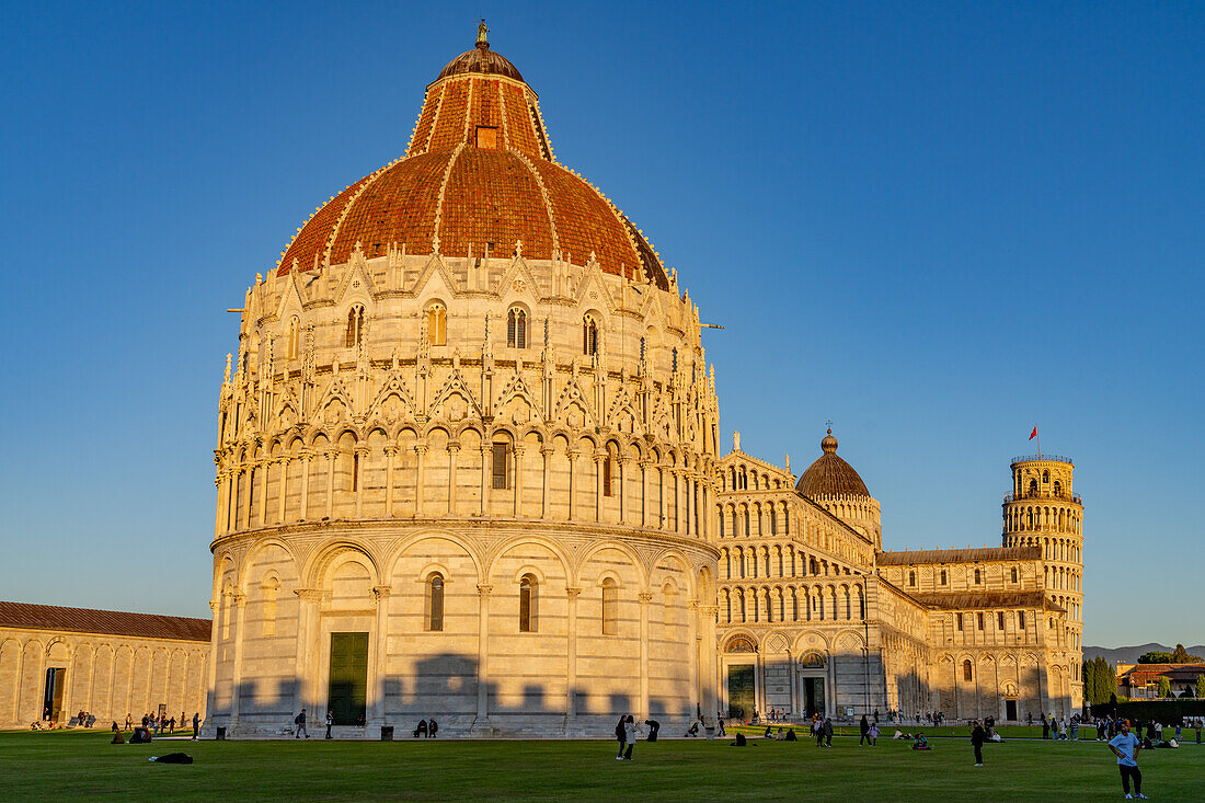 Baptistery of St. John, the Pisa Cathedral and Leaning Tower in the Piazza dei Miracoli in Pisa, Italy. The top half of the baptistery is Gothic style, while the lower half is Romanesque.