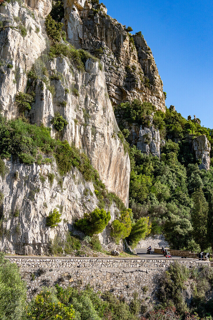 Motorcyclists on the winding Amalfi Coast road in Italy.