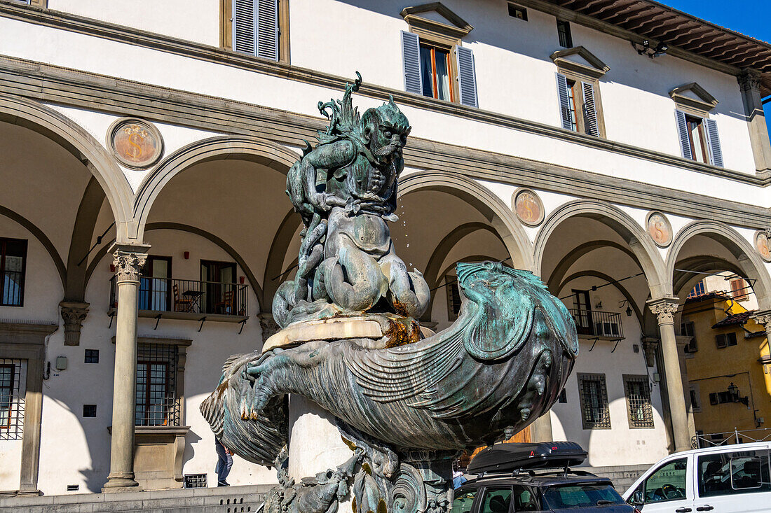 Fountain statue of a sea monster on the Piazza Santissima Annunciata, Florence, Italy. Behind is the Loggiato dei Serviti, now a hotel.