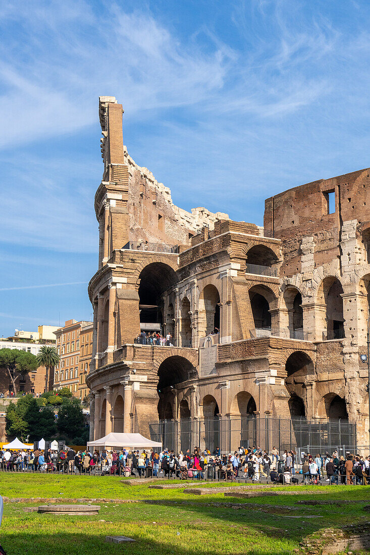 Tourists and the ancient Roman Colosseum or Flavian Amphitheater in Rome, Italy.