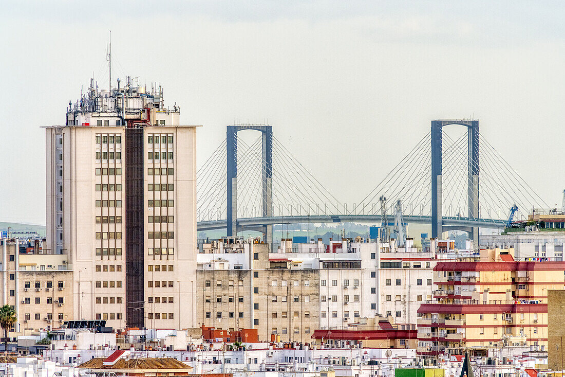 Blick auf ein Stadtbild mit einem markanten Turm und einer Brücke bei klarem Himmel