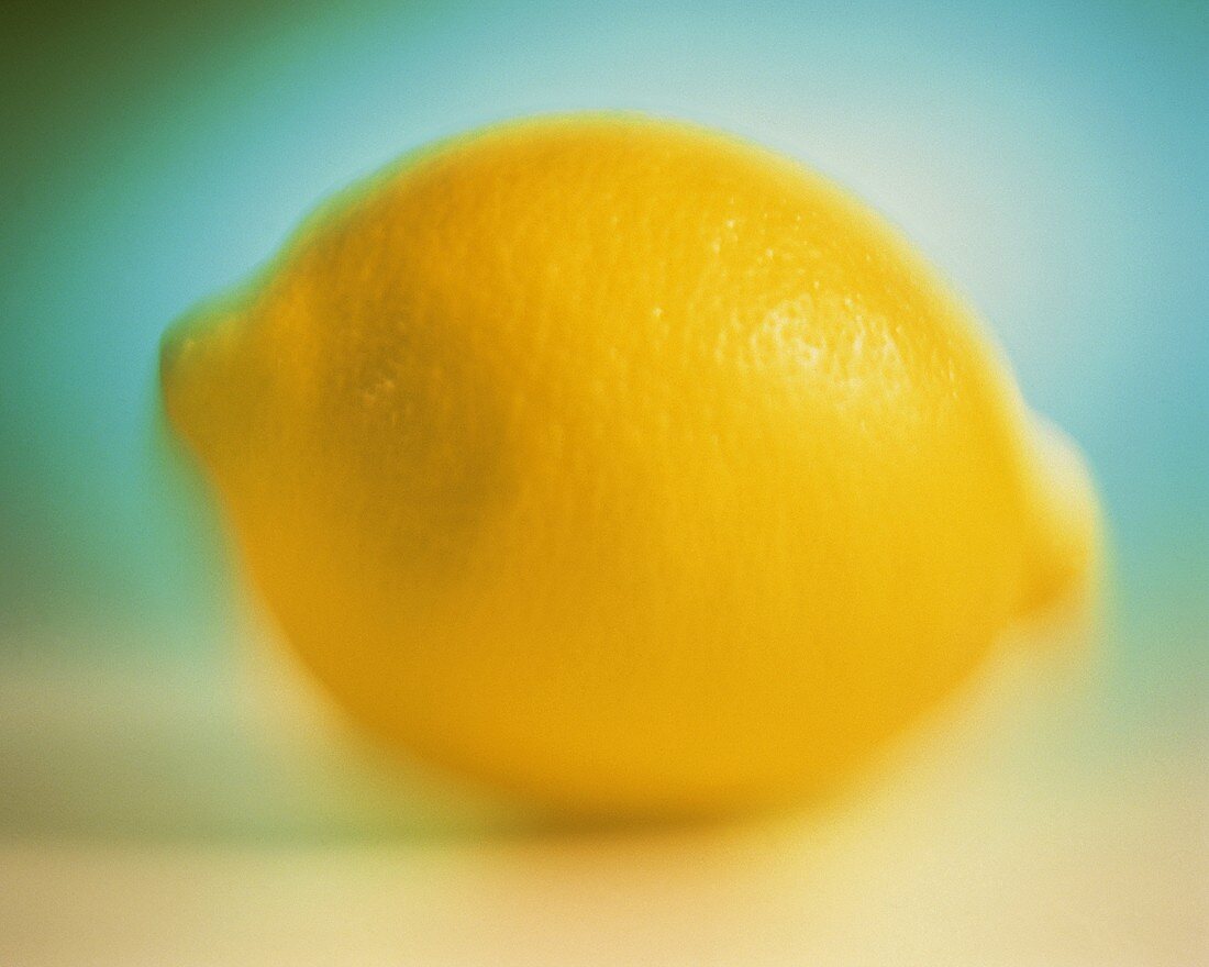 Eine Zitrone vor türkisfarbenem Hintergrund