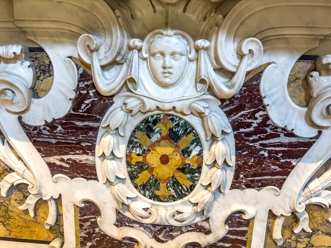 Baas relief marble sculpture and marble inlay in the crypt of the Basilica of Sant'Antonino, Sorrento, Italy. The inlaid floral pattern is also called Florentine mosaic or commessa.