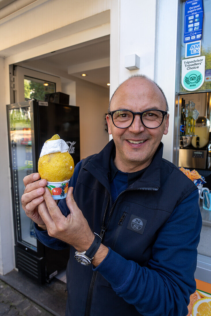 A shop proprietor with a lemon sorbet in Anacapri on the island of Capri, Italy.