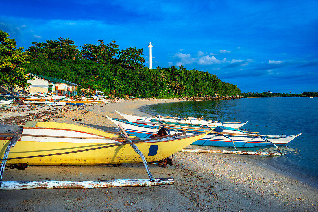 Einheimische Fischboote am Guimbitayan-Strand neben dem weißen Sandstrand auf der Insel Malapascua, Cebu, Philippinen