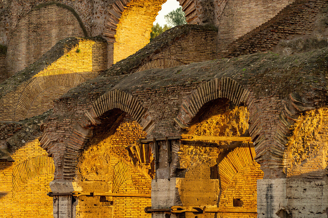 Detail des Innenraums des römischen Kolosseums oder flavischen Amphitheaters im goldenen Licht des Sonnenuntergangs in Rom, Italien.