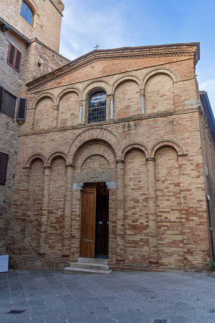 Die Fassade der Kirche San Bartolo aus dem 13. Jahrhundert in der mittelalterlichen Stadt San Gimignano, Italien.