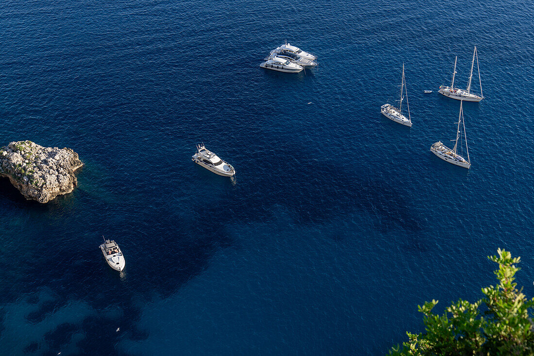 Pleasure boats in the clear waters of the Tyrrhenian Sea off the coast of the island of Capri, Italy.