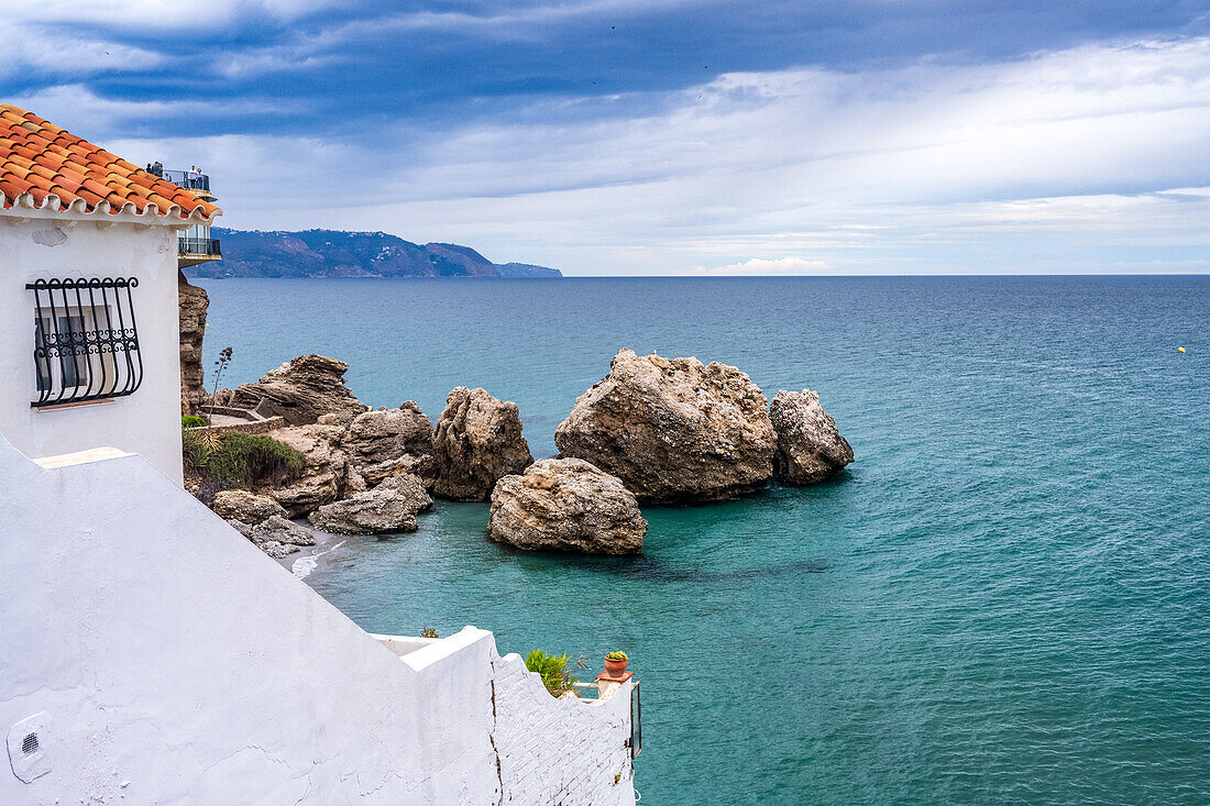 Malerische Küstenansicht in Nerja, Malaga, Spanien, mit blauem Meer und felsiger Landschaft.