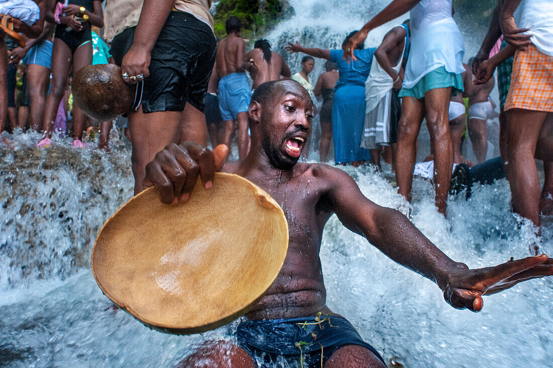 Haiti Voodoo Festival in Saut d'Eau, in Saut d'Eau, Ville Bonheur, Haiti. Thousands of both Vodou and Catholic followers gathered under the Saut d'Eau waterfall in Haiti. The pilgrimage, made by Voodou practitioners and Catholics alike, originated with the sighting of the likeness of the Virgin Mary on a palm leaf close to the falls half a century ago. Catholism and Voodou practices are forever intertwined in its Haitian form. The appearance of a rainbow beneath the falls is said indicate that Danbala - the great lord of the waterfall - and Ayida Wedo - the rainbow - are making love. Fertility