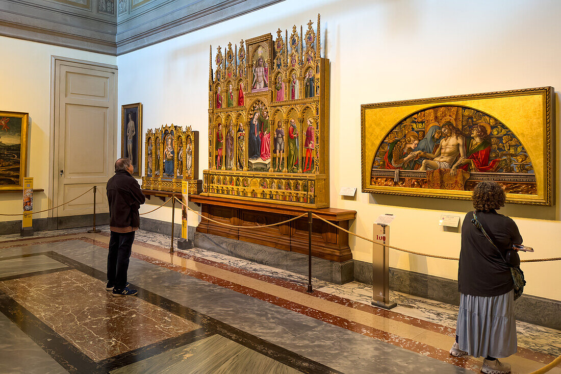 Visitors view religious paintings in the Pinacoteca, Vatican Museums, Vatican City, Rome, Italy.