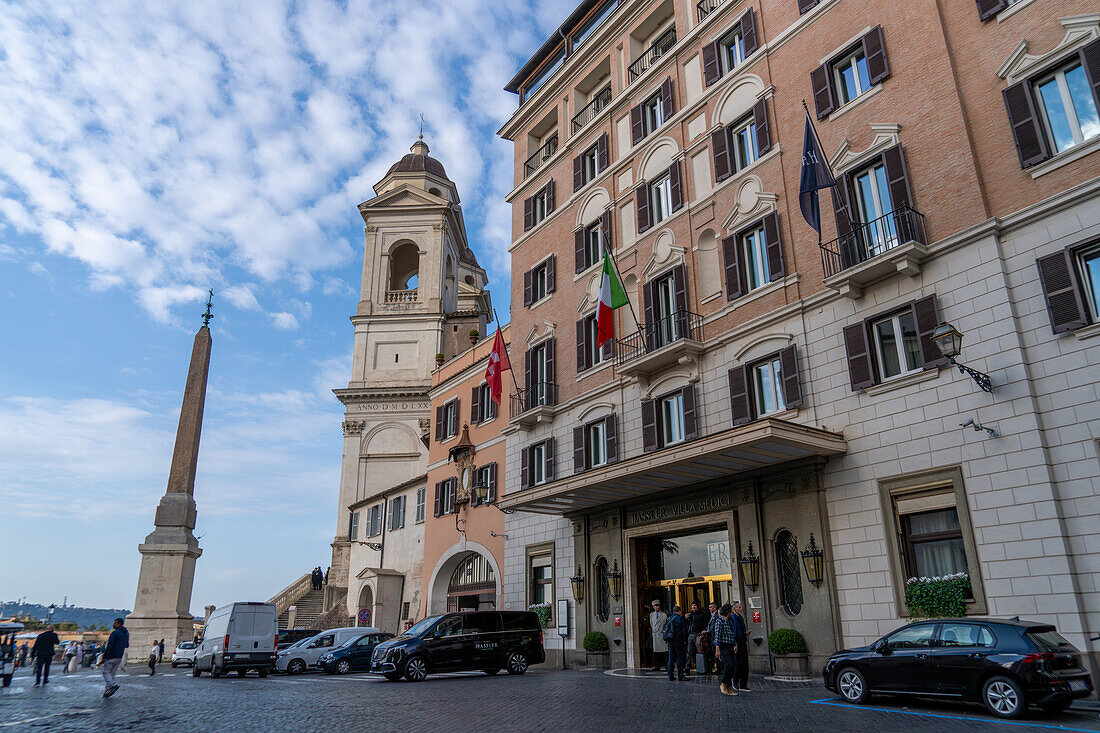 The luxury Roma Hassler Hotel on the Piazza Trinita dei Monti at the top of the Spanish Steps in Rome, Italy. At left is the Trinita dei Monti Church and Sallustiano Obelisk.