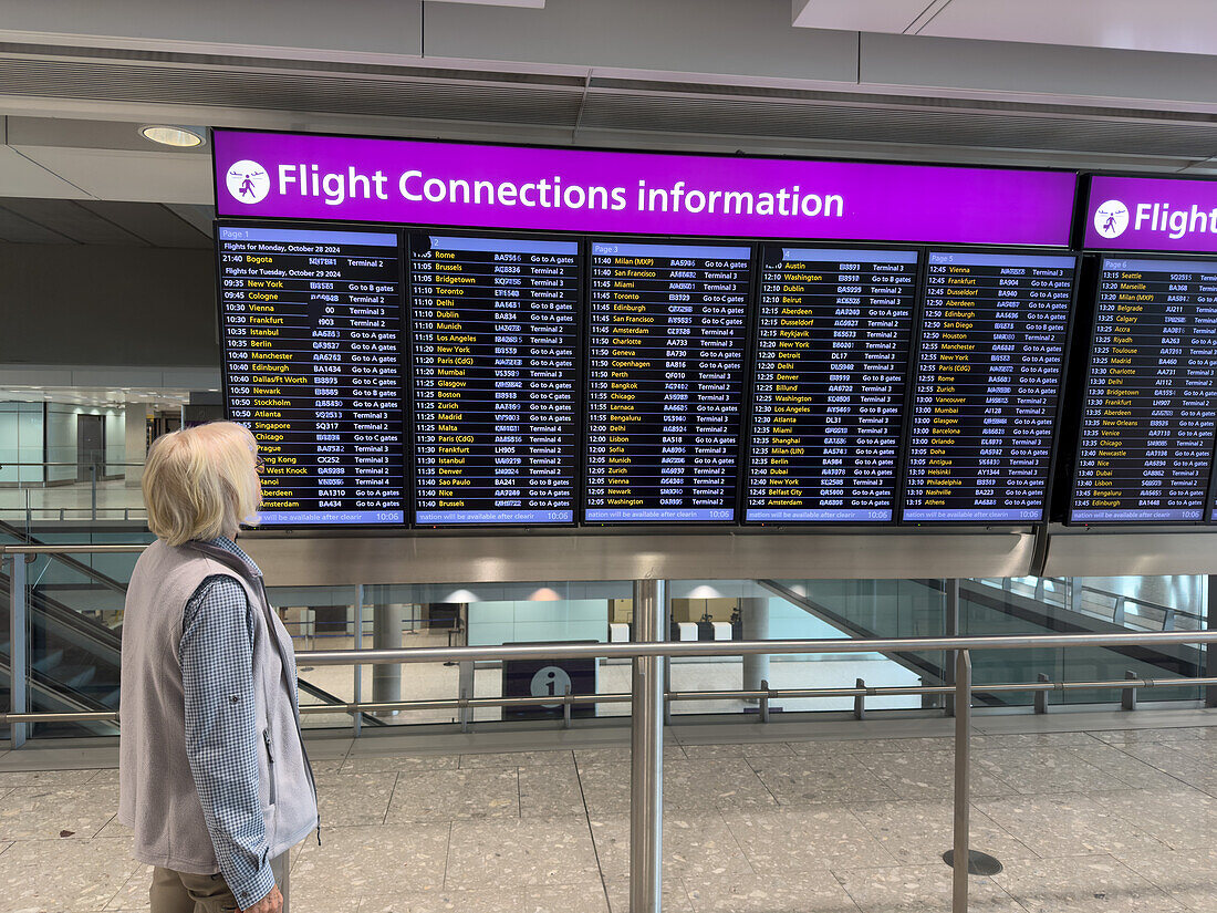 A traveler looks at the flight connections information screen at Heathrow Airport, London, England.