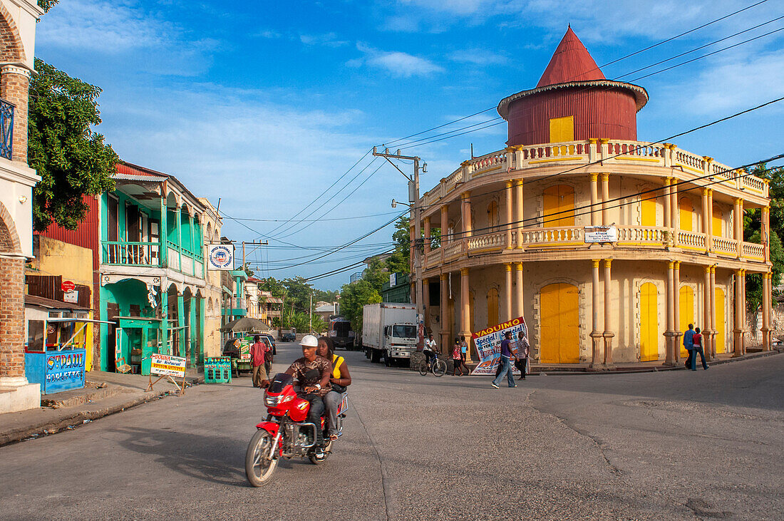 Local people in a motorbike and houses in the historic colonial old town, Jacmel city center, Haiti, West Indies, Caribbean, Central America