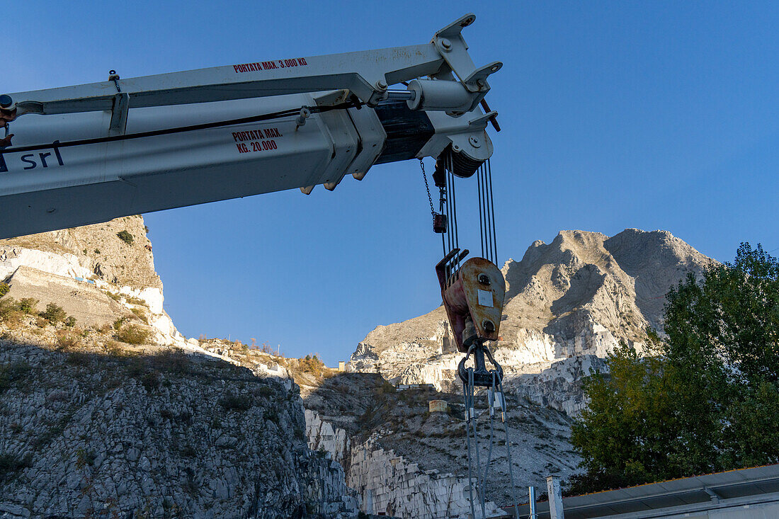 A crane for moving blocks of marble near the quarries in Fantiscriiti, near Carrara, Italy. The quarries are visible on the mountain behind.