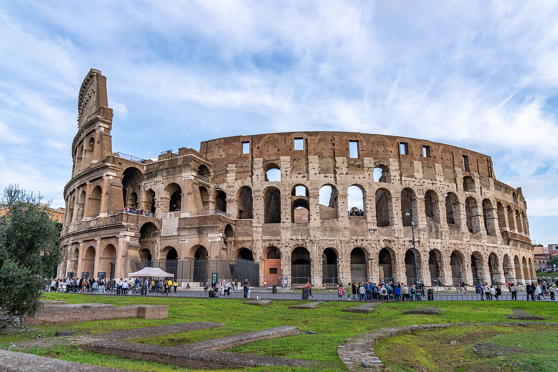 Tourists and the ancient Roman Colosseum or Flavian Amphitheater in Rome, Italy.