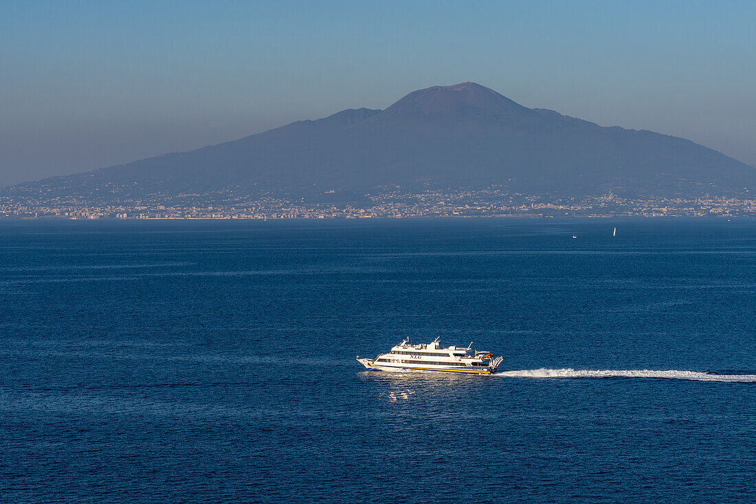 A high-speed passenger ferry in the Bay of Naples with Mount Vesuvius behind. Sorrento, Italy.