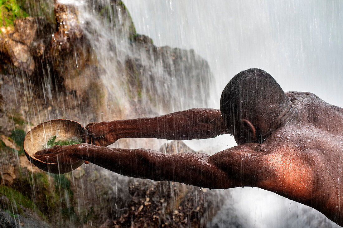 Haiti Voodoo Festival in Saut d'Eau, in Saut d'Eau, Ville Bonheur, Haiti. Tausende von Vodou- und katholischen Anhängern versammelten sich unter dem Wasserfall von Saut d'Eau in Haiti. Die Wallfahrt, die sowohl von Voodou-Anhängern als auch von Katholiken unternommen wird, hat ihren Ursprung in der Sichtung des Bildes der Jungfrau Maria auf einem Palmblatt in der Nähe des Wasserfalls vor einem halben Jahrhundert. Der Katholizismus und die Voodou-Praktiken sind in ihrer haitianischen Form für immer miteinander verwoben. Das Erscheinen eines Regenbogens unter den Wasserfällen soll bedeuten, dass