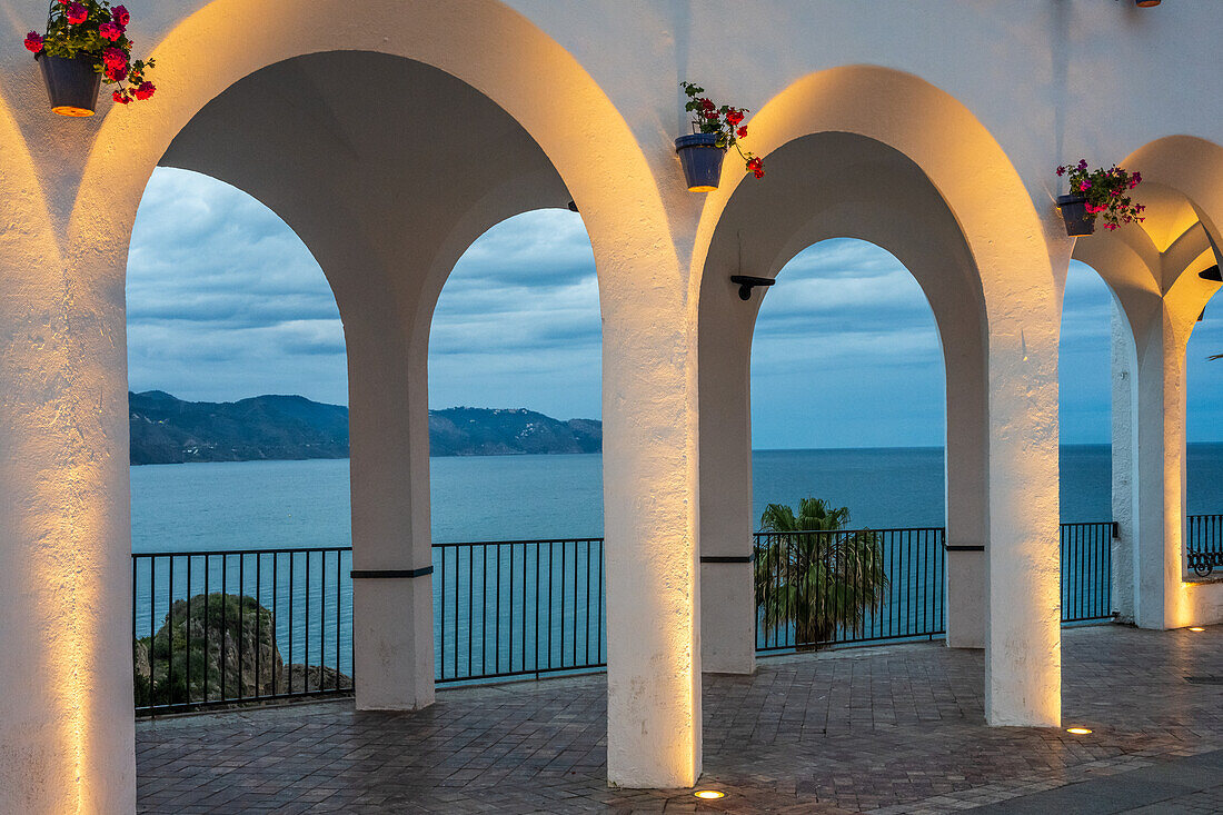 Glowing arches overlooking the sea at Plaza del Balcon de Europa in Nerja, Spain.