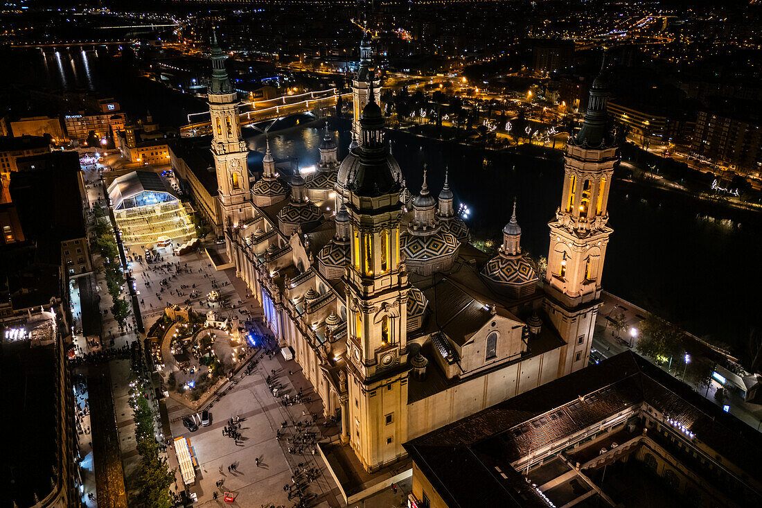 Aerial view of the Cathedral Basilica of of Our Lady of the Pillar and El Pilar square illuminated at night during Christmas, Zaragoza, Spain