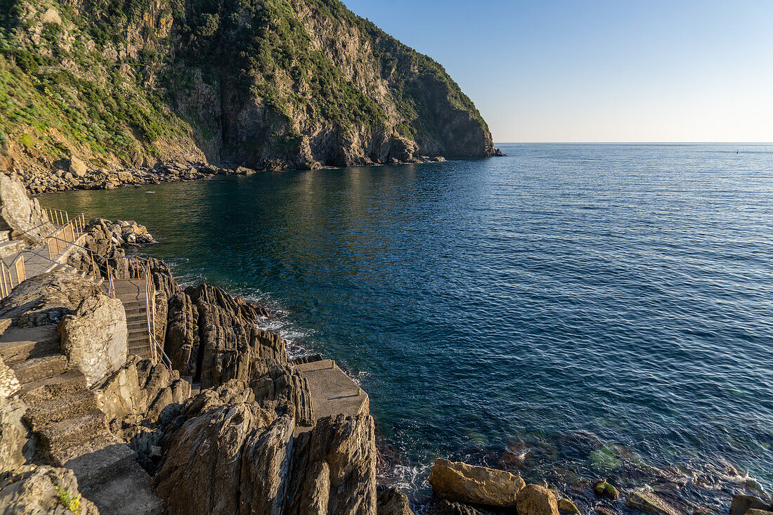 Ein Spazierweg auf den Felsen entlang des Lingurischen Meeres bei Riomaggiore, Cinque Terre, Italien.