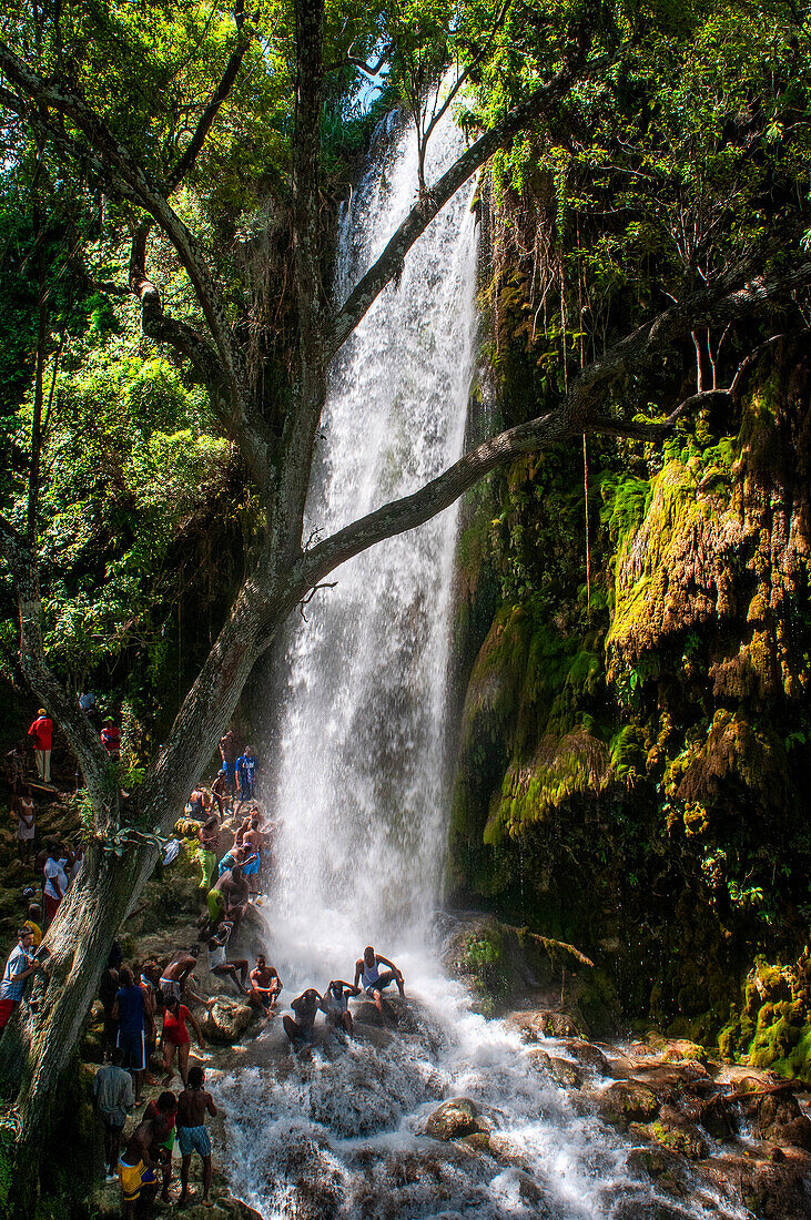 Haiti Voodoo Festival in Saut d'Eau, in Saut d'Eau, Ville Bonheur, Haiti. Tausende von Vodou- und katholischen Anhängern versammelten sich unter dem Wasserfall von Saut d'Eau in Haiti. Die Wallfahrt, die sowohl von Voodou-Anhängern als auch von Katholiken unternommen wird, hat ihren Ursprung in der Sichtung des Bildes der Jungfrau Maria auf einem Palmblatt in der Nähe des Wasserfalls vor einem halben Jahrhundert. Der Katholizismus und die Voodou-Praktiken sind in ihrer haitianischen Form für immer miteinander verwoben. Das Erscheinen eines Regenbogens unter den Wasserfällen soll bedeuten, dass