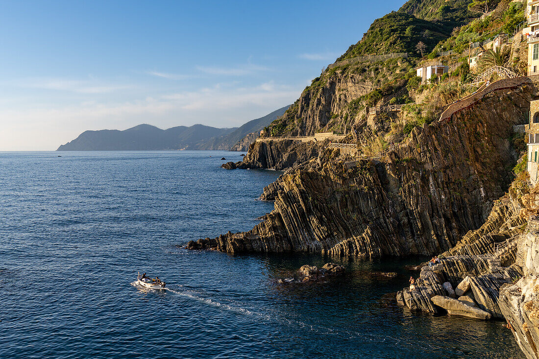 Fischer in einem kleinen Boot verlassen den Hafen in Riomaggiore, Cinque Terre, Italien.