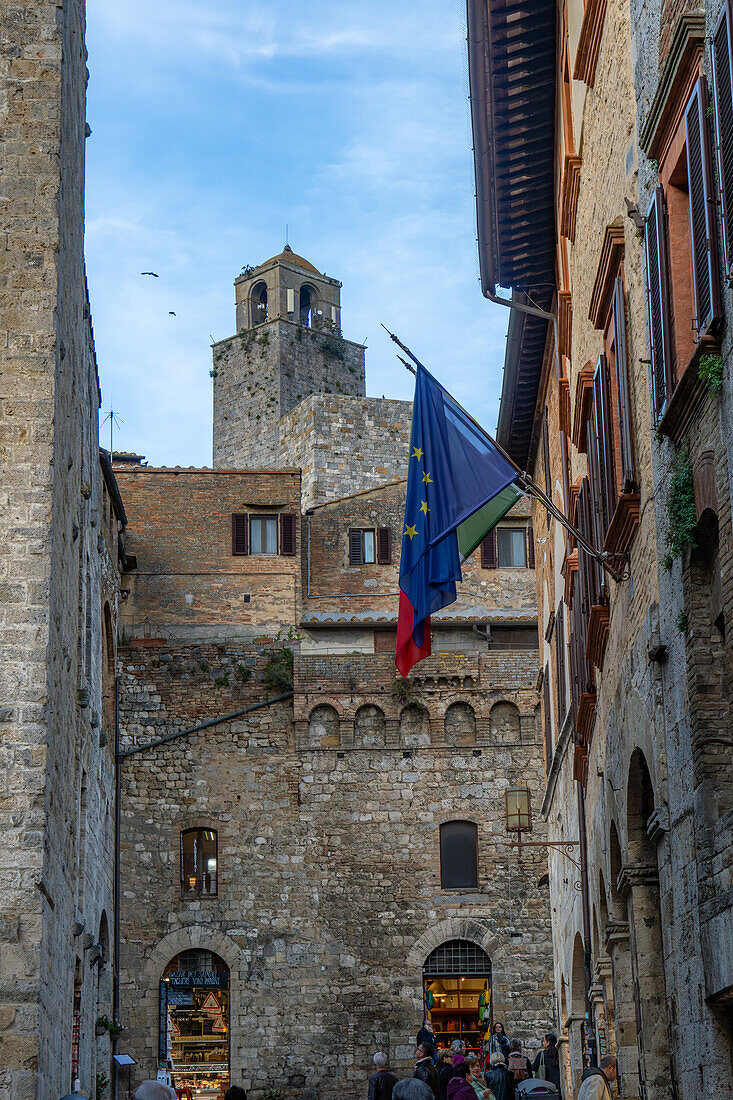 The top of the Torre Rognosa above buildings on Via San Giovanni in the medieval city of San Gemignano, Italy.