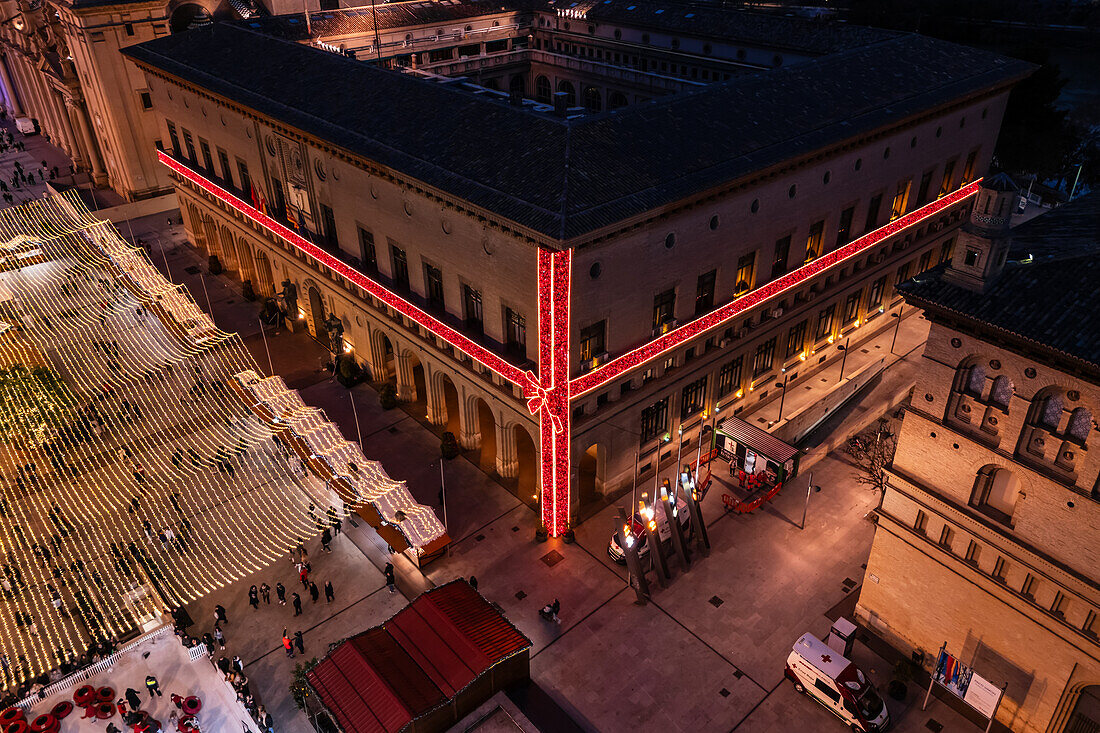 Luftaufnahme der nächtlich beleuchteten Weihnachtsdekoration und -unterhaltung auf dem El Pilar-Platz in Zaragoza, Spanien