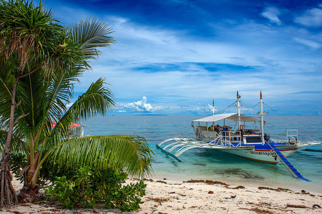 Traditional boats moored off a tiny tropical island beach in the Philippines Kalanggaman island, Malapascua, Cebu, Philippines