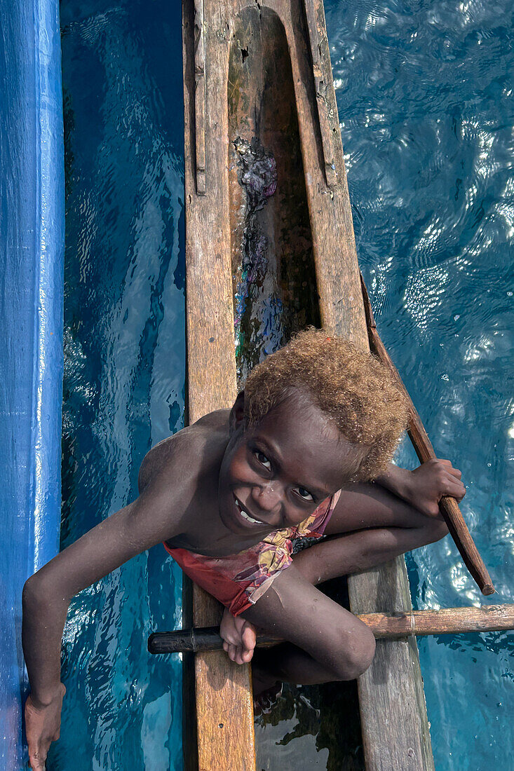 Residents of Tungelo Island in their traditional dugout canoes, New Ireland province, Papua New Guinea