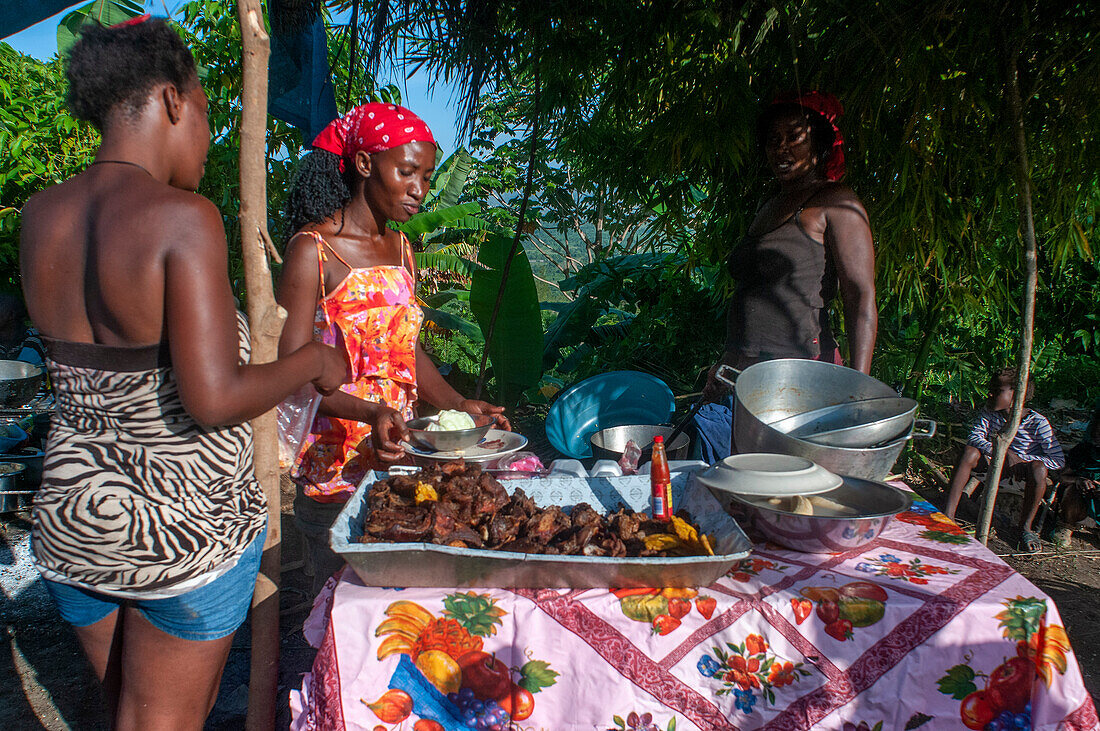 Food stall during Haiti Voodoo Festival in Saut d'Eau, in Saut d'Eau, Ville Bonheur, Haiti. Thousands of both Vodou and Catholic followers gathered under the Saut d'Eau waterfall in Haiti. The pilgrimage, made by Voodou practitioners and Catholics alike, originated with the sighting of the likeness of the Virgin Mary on a palm leaf close to the falls half a century ago. Catholism and Voodou practices are forever intertwined in its Haitian form. The appearance of a rainbow beneath the falls is said indicate that Danbala - the great lord of the waterfall - and Ayida Wedo - the rainbow - are maki