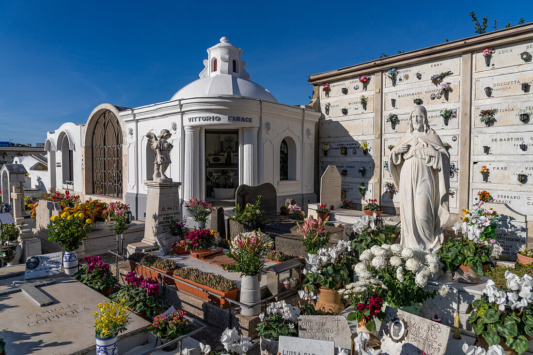 Blumen schmücken die Gräber auf einem Friedhof in Anacapri auf der Insel Capri, Italien.