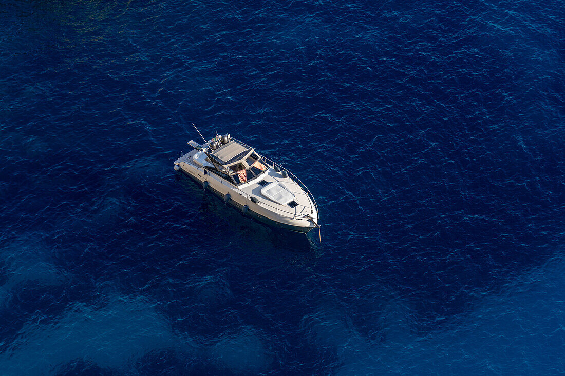 A pleasure boat in the clear waters of the Tyrrhenian Sea off the coast of the island of Capri, Italy.