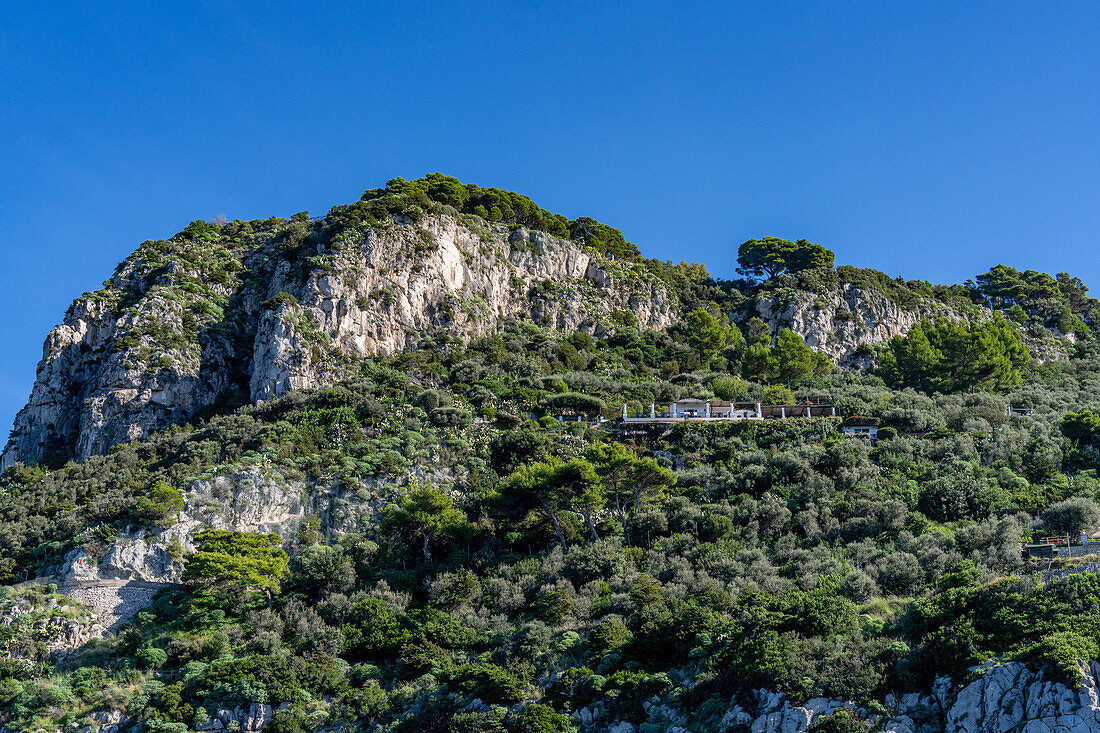 Eine Luxusvilla unterhalb der Kalksteinklippen an der Westküste der Insel Capri, Italien.