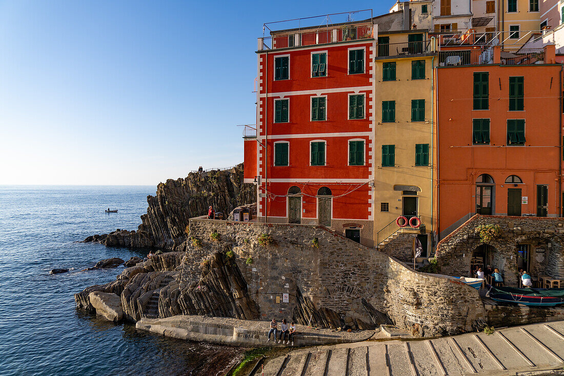 Ein buntes Gebäude mit Blick auf den Hafen und das Lingurische Meer in Riomaggiore, Cinque Terre, Italien.