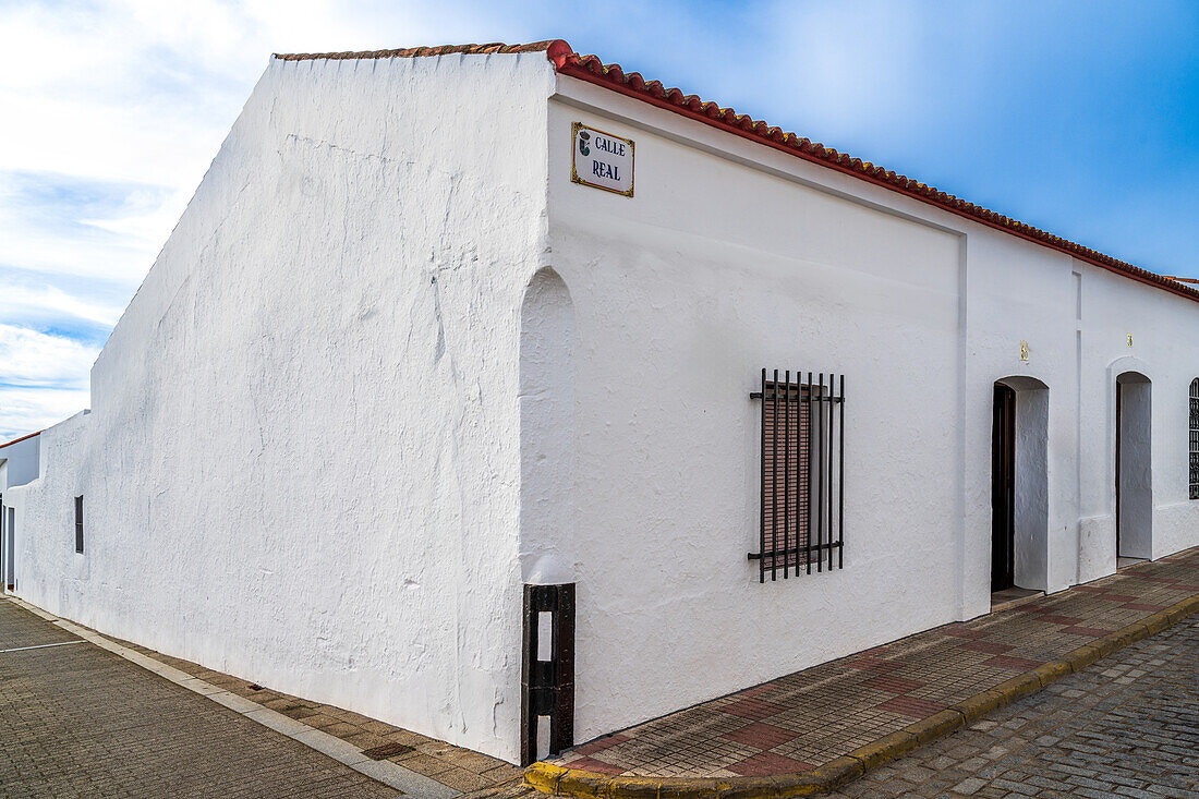 A vibrant view of whitewashed buildings along Calle Real in Alosno, Andalusia.